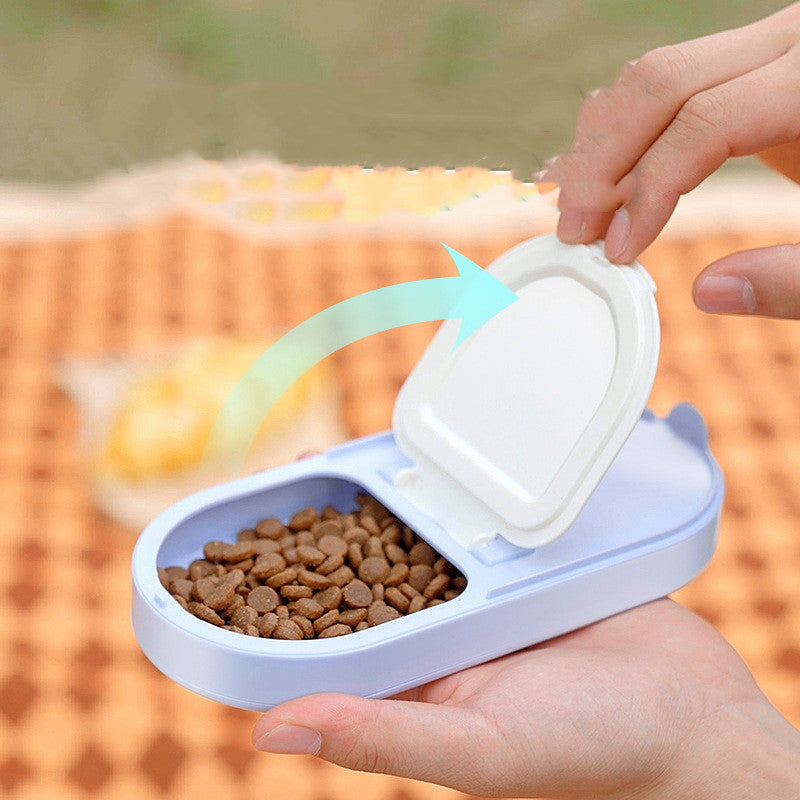 Person holding a portable pet food container with kibble, featuring a flip-top lid in a serene outdoor setting.