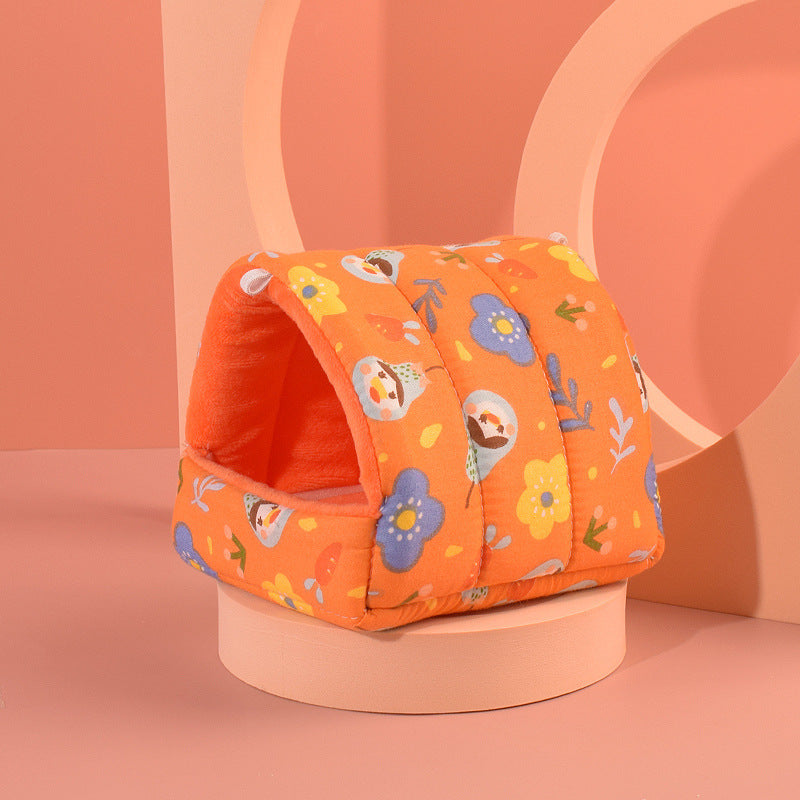 Cozy orange hamster nest with colorful flower and animal patterns, perfect for small pets to snuggle in.